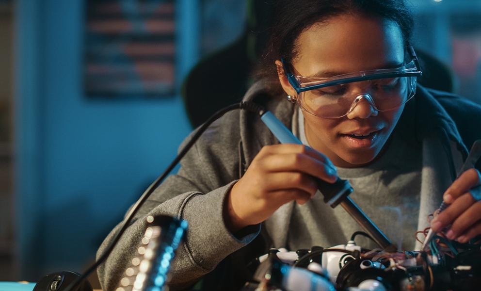 Young woman working on robotics parts